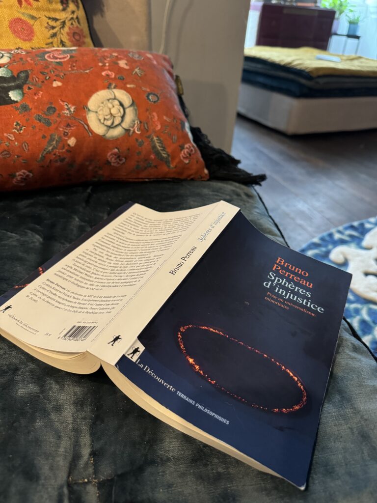 le livre Sphères d'injustice de Bruno Perreau. L'ouvrage est ouvert et posé retourné sur mon canapé