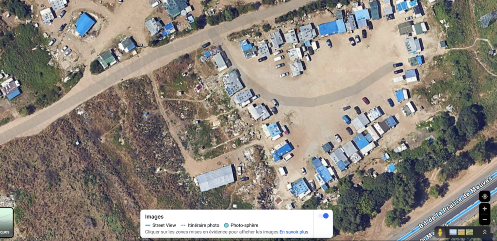 image satellite Google montrant le camp vu du cielOn y voit un terrain en terre et de nombreuses caravanes réparties dans l'espace selon des lignes verticales et horizontales