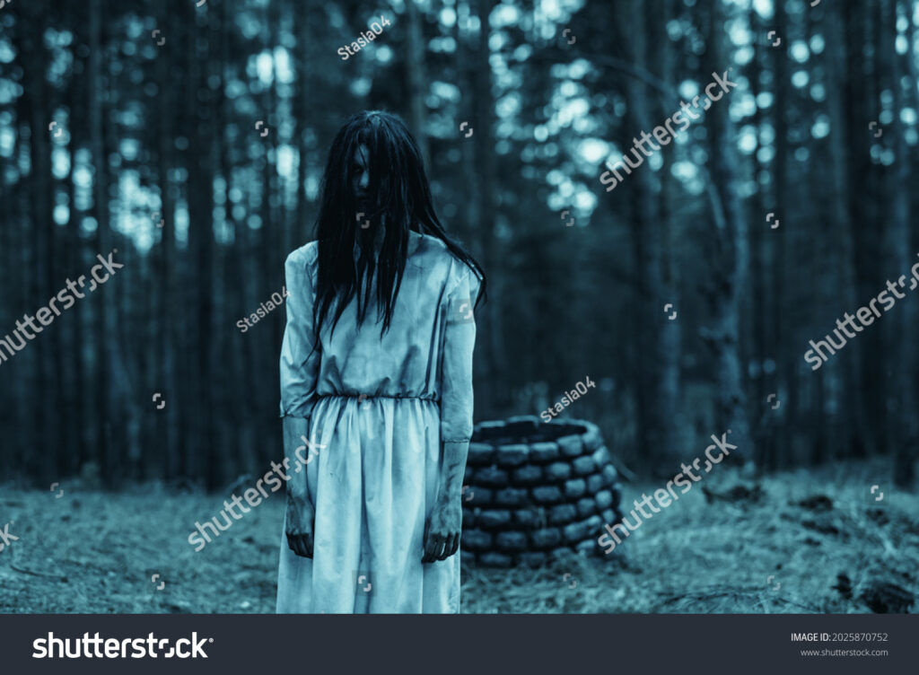 Une imitation d'une scène culture du film The Ring ou l'on voit une jeune femme habillée d'une robe blanche salie, les longs cheveux devant le visage, derrière elle un puit en pierre. La photo est vendue sur ShutterStock