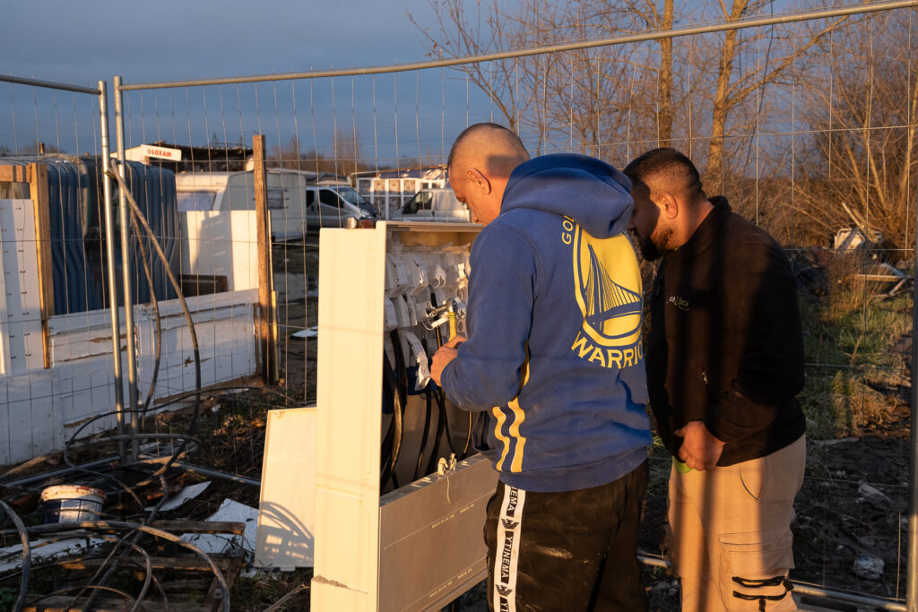 Deux hommes font un branchement sur un tableau électrique
