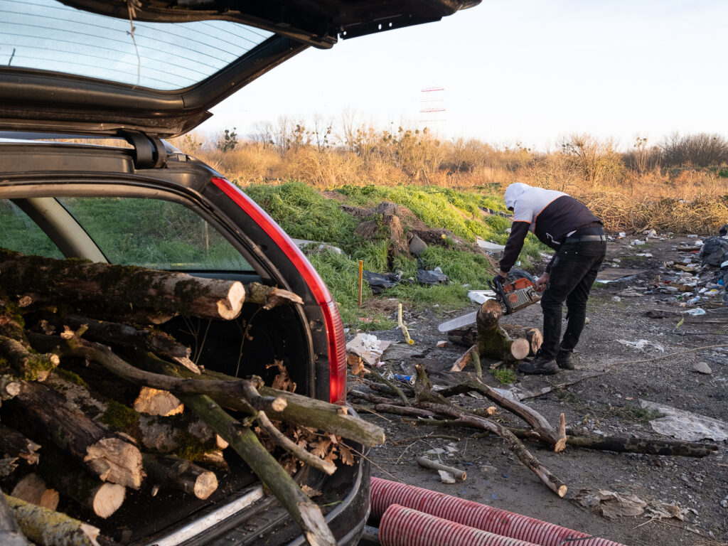 un homme tronçonne des grosses blanches et les met dans le coffre d'une voiture